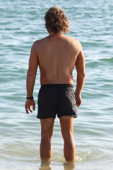 A man in swimming trunks on the seashore.