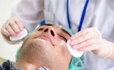 Naklejka premium Young man visiting female doctor cosmetologyst
