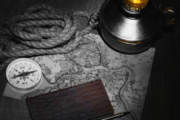 preparation for travel on an old map with a compass a dark background