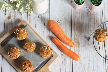 Fresh homemade delicious carrot muffins decorated with oat flakes and brown sugar on rustic table