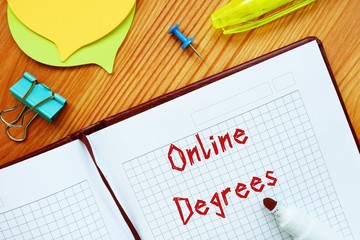 Educational concept meaning Online Degrees with phrase on the sheet.