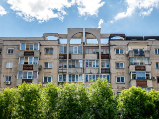 Worn out apartment building from the communist era against blue sky in Bucharest Romania. Ugly...