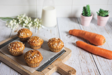 Fresh homemade delicious carrot muffins decorated with oat flakes and brown sugar on rustic table