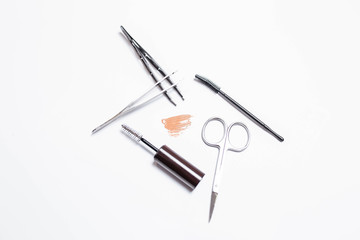 Makeup brushes, scissors, tweezers, mascara on a white background. Makeup. Beauty and fashion.