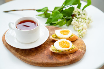 tea and sandwich with avocado and egg.