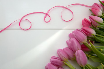 Pink tulips and loop isolated on white wood Background.
