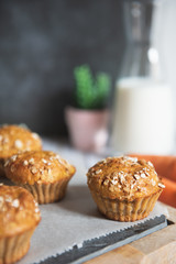Fresh homemade delicious carrot muffins decorated with oat flakes and brown sugar on rustic table