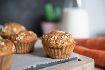 Fresh homemade delicious carrot muffins decorated with oat flakes and brown sugar on rustic table