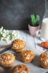 Fresh homemade delicious carrot muffins decorated with oat flakes and brown sugar on rustic table