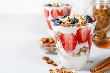 Granola Parfait with greek yogurt, oat cereal, fresh berries, honey in glass jar