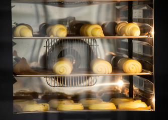 Baking tray with delicious croissants in oven