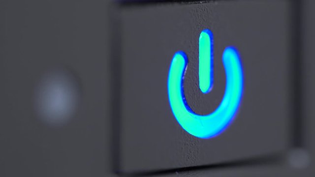 Macro detail of a power button being pressed and the device turned on