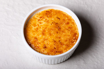 Fresh crème brulee in a small white bowl close-up