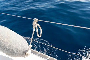 Sailing knot with white sailing rope on the deck of the boat