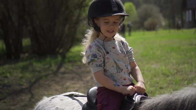 Lovely girl child ride unicorn pony horse. Gimbal stabilizer movement shot