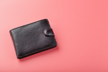 Black wallet on pink background. Symbol of prosperity and prosperity.
