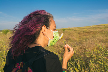 Woman With A Sanitary Mask After The Coronavirus Outbreak In Spain. Adult Woman In The Field Enjoying Nature And Smelling A Flower. Covid 19. Lifestyle.