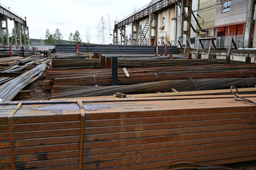 Photo of black metal lay in stacks of pallets outdoors