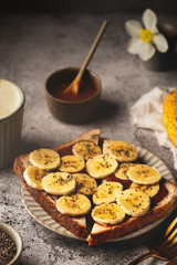 Sandwich with caramel, banana and chia seeds. Delicious breakfast concept with coffee.