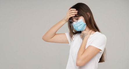 Asian woman in face protective mask feeling unwell  on grey studio background. Copy space for text. The first defense against the epidemic of flu and coronavirus