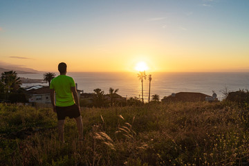 Fototapeta na wymiar Runner watching the sunset from Tenerife. The Atlantic ocean is observed.