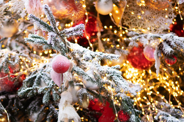 Fototapeta na wymiar Christmas and New Year. Decorations of balls and lights on a snowy tree branch.