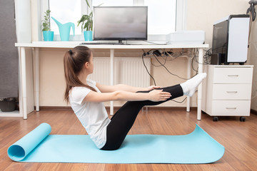 Beauty and health at home during a pandemic quarantine. Girl practices yoga via the Internet