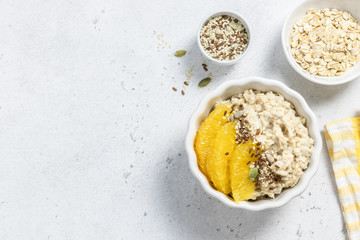 Vegetarian healthy breakfast oats with orange and seeds. Top view, copy space.