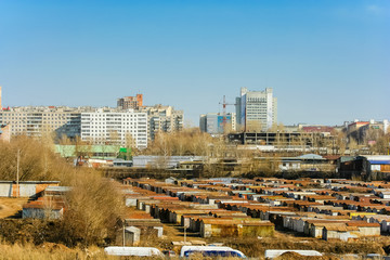 View of the industrial city, garages and construction site on a summer day
