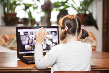 Study online with video call teacher. Young girl learn online and looking at laptop at home.Social distancing.