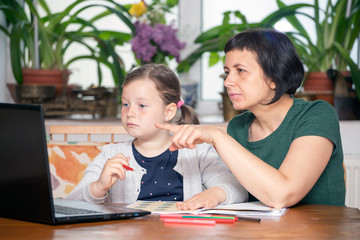 Study online with video call teacher. Young girl learn online and looking at laptop at home.Social distancing.