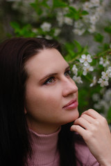 portrait of a young girl in a blossoming apple tree