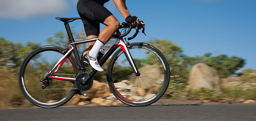 Road bike cyclist man cycling, athlete on a race cycle. Panning technique used