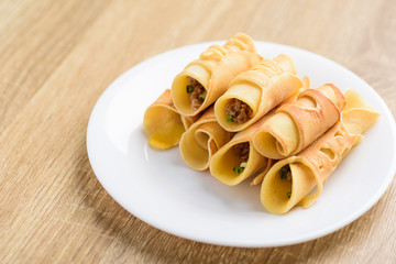 Thai dessert (Khanom Tokyo), pancake roll stuff with minced pork on white plate
