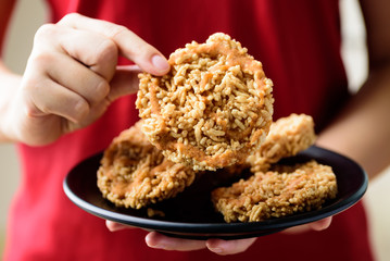 Deep fried sweet crispy rice with cane sugar drizzle eating by hand, Local Thai snack (Khao Tan)