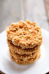 Stack of deep fried sweet crispy rice with cane sugar drizzle on white plate, Local Thai snack (Khao Tan)	