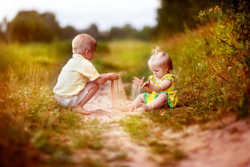 Fototapeta premium children, brother and sister, walking in the meadow, road, happy child, nature, summer in the village