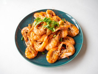 Baked Shrimp Whole shell with salt, frogs, garlic for fragrance Garnish with spring onions and coriander on a round dish,White background