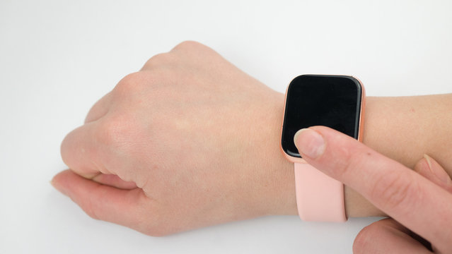 Woman's Hand Touching The Screen Of A Smart Watch On White Background