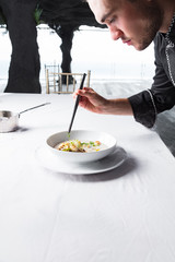 Cook chef making creme soup with herbs, mushrooms, scallops and toast bred - added dried ice for smoking effect.