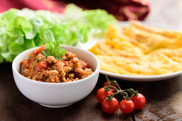 Northern Thai food (Nam Prik Ong), spicy chili minced pork with tomatoes in a bowl eating with omelette, Thai chili paste
