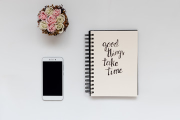 Flat lay of office supplies, notebook with motivational quote, smartphone for mock-up