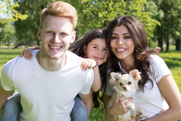 Obraz premium Happy smiling family with pet dog