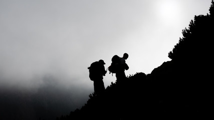 Hikers climbing towards the mist