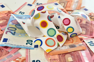 Shattered cup on top of euro bills symbolizing economic fallout due to coronavirus pandemic crisis.