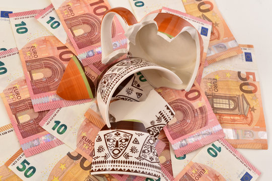 Shattered Cup On Top Of Euro Bills Symbolizing Economic Fallout Due To Coronavirus Pandemic Crisis.