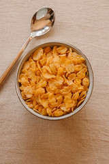 Cornflakes on a bowl on rustic background. Top view. 