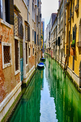 Fototapeta na wymiar Lonely canal in Venice with two boats