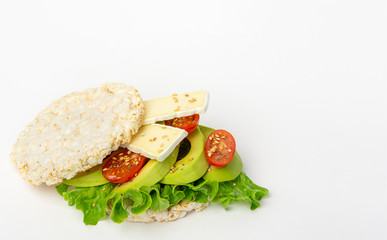 Puffed rice cakes sandwich with avocado, cherry tomatoes and cheese brie. Healthy lifestyle concept