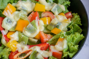 top view mix fruit and vegetable salad on black dish